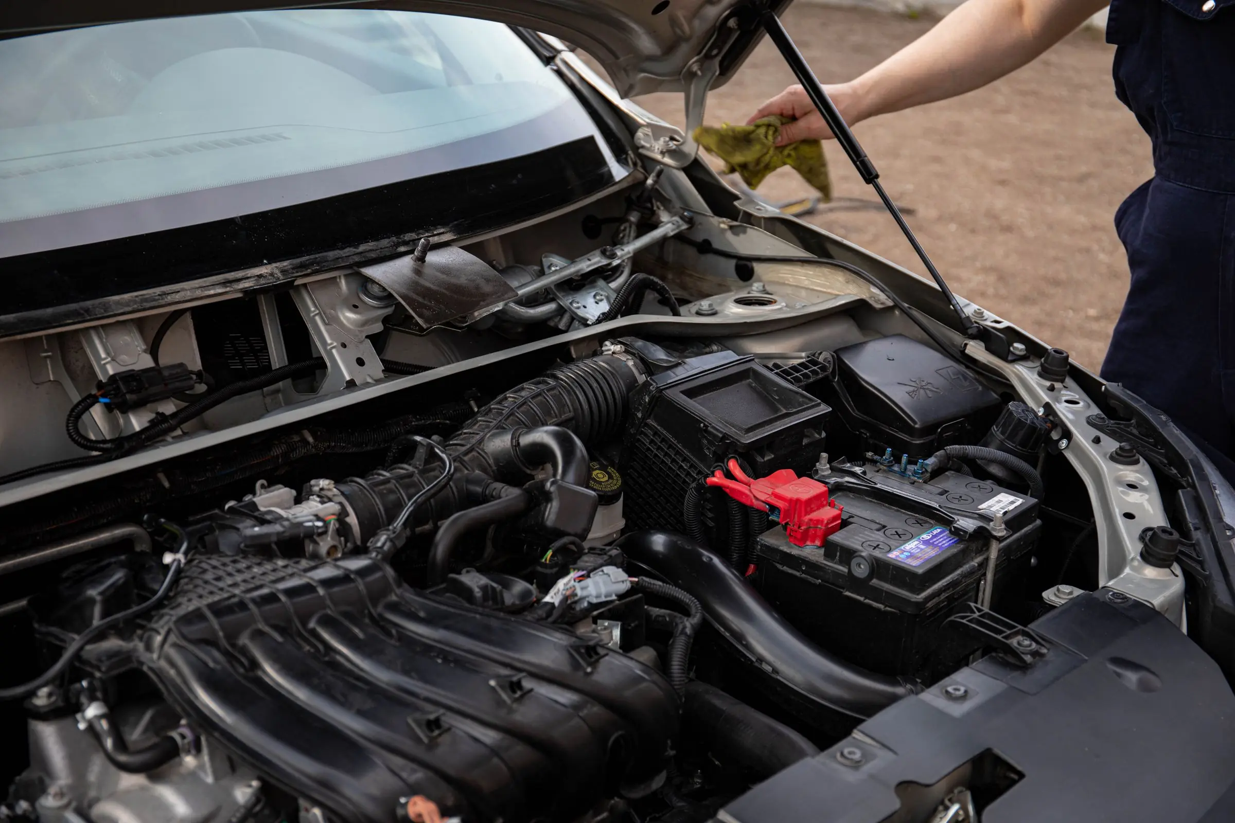 Une voiture capot ouvert, le moteur et la batterie bien visibles